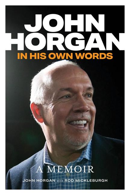 John Horgan in his own words, a man with a light skin tone and light grey stubble, smiling and wearing a suit with a spotlight on him.